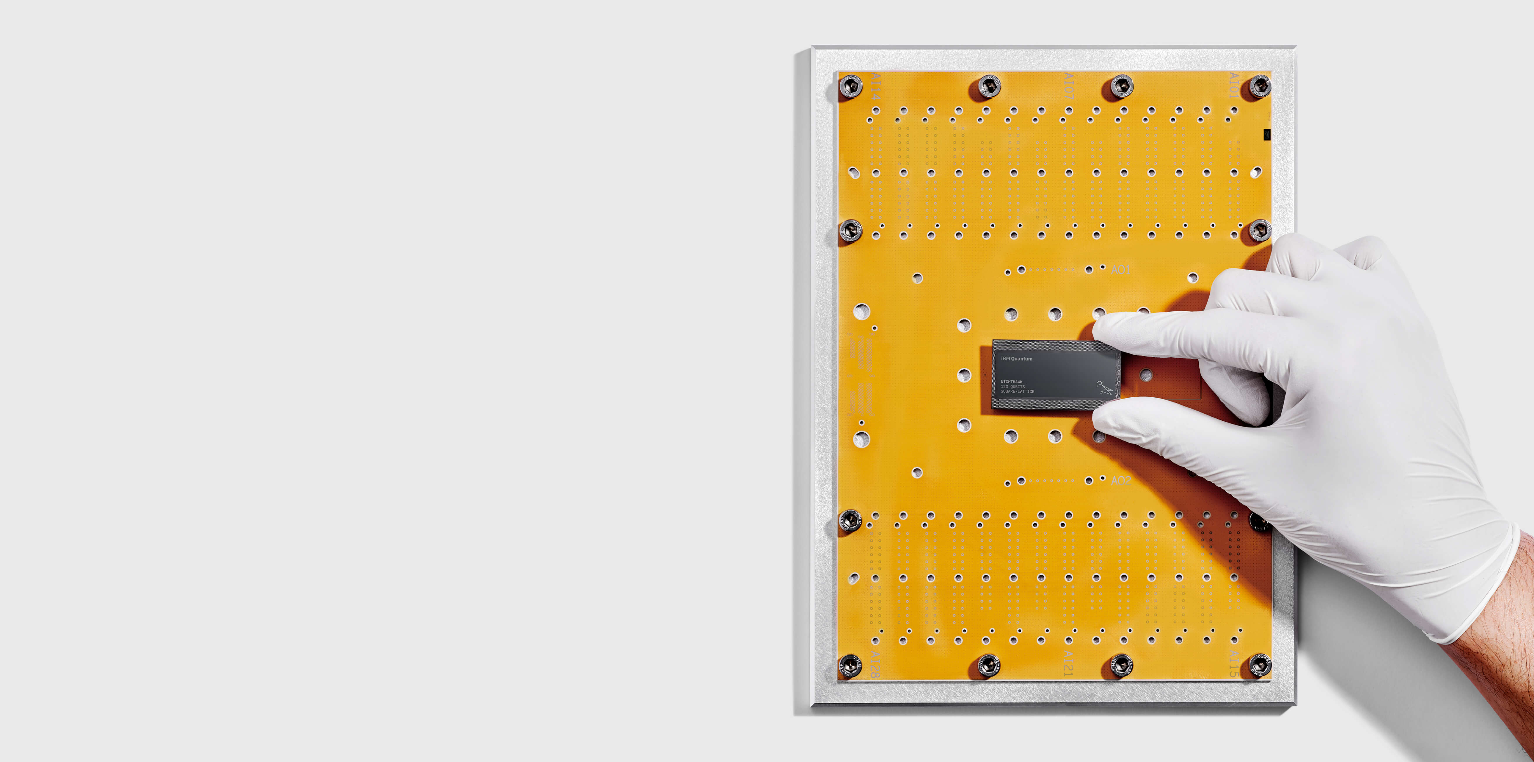 A gloved researcher handling an IBM Quantum Nighthawk processor