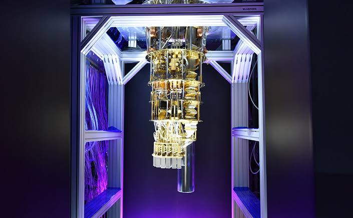 Quantum cryostat suspended inside a purple-lit laboratory frame